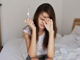 woman with a thermometer in her hands upset fever photo