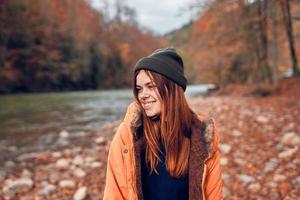 cheerful woman Tourist in a jacket Autumn forest river nature photo