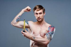 tattooed man muscular bodybuilder Fitness gray background photo