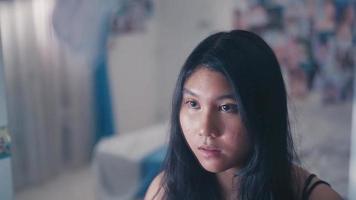 an asian teenager looks in the mirror with a feeling of insecurity because her face video