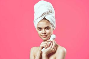 woman with a towel on her head massagers in hands clean skin health care photo