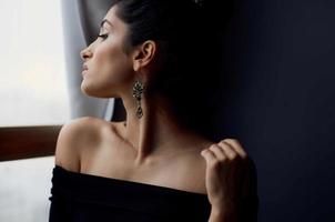 pretty woman near window posing attractive look earrings elegant style photo