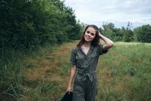 Woman portrait on nature Green jumpsuit fresh air straightens hair photo