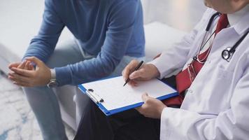 psychiatre homme à Accueil dans psychothérapie session avec le sien Masculin patient. Masculin psychiatre écoute à le problèmes de le sien Jeune patient, prise Remarques à diagnostiquer lui. video