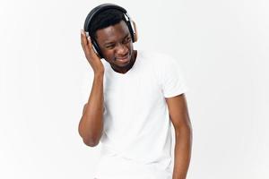 man of african appearance in white t-shirt with headphones listening to music technology studio photo