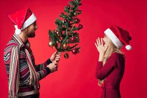 cheerful young couple holiday christmas gift decoration red background photo