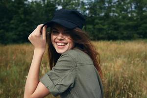 contento mujer en azul gorra y verde camisa se ríe foto