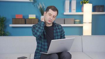 homme en utilisant portable à Accueil a une douleur dans le sien cou, il fait mal, il a mixte des douleurs. homme avec cou douleur est Souffrance à maison, il ne fait pas ressentir confortable, il Besoins médicament. video