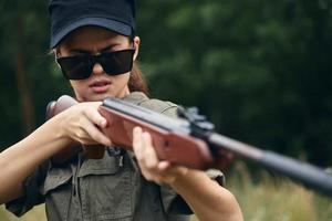 Woman Sunglasses weapon aiming green leaves green photo