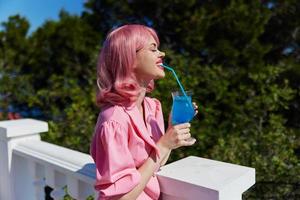 glamorous woman in pink dress outdoors with cocktail Drinking alcohol photo