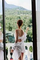 pretty woman in lingerie on the balcony beautiful view from the window Relaxation concept photo