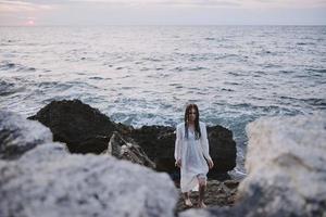 atractivo mujer camina volcánico rock formaciones en el isla naturaleza foto