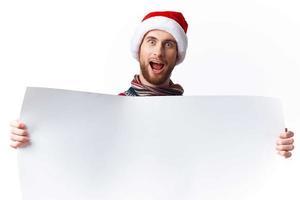 Cheerful man in New Year's clothes holding a banner holiday light background photo