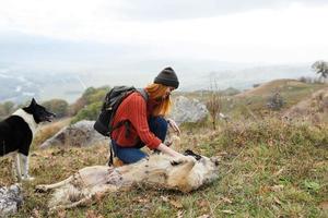 mujer viajes en el montañas con un perro amistad foto