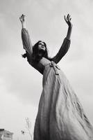 pretty woman in dress gesturing with hands posing black and white photo