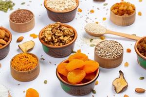 Healthy vegetarian food concept. Assortment of dried fruits, nuts and seeds on white background. Top view. photo