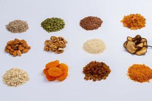 Healthy vegetarian food concept. Assortment of dried fruits, nuts and seeds on white background. Top view. photo