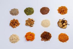 Healthy vegetarian food concept. Assortment of dried fruits, nuts and seeds on white background. Top view. photo