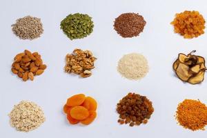 Healthy vegetarian food concept. Assortment of dried fruits, nuts and seeds on white background. Top view. photo