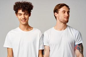 two men in white t-shirts are standing next to friendship emotions photo