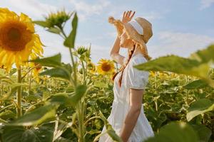 beautiful sweet girl in a straw hat in a white dress a field of sunflowers agriculture countryside photo