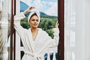 retrato mujer en un blanco túnica en el balcón poco en verde naturaleza montaña ver foto