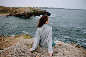 woman beach tourism cloudy weather stone coast female relaxing photo