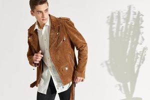 a gentleman in a shirt and a jacket on a light background gestures with his hands photo