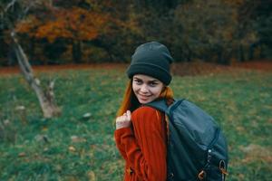 happy traveler resting in nature with backpack on her back back view photo