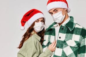 young couple wearing medical masks christmas hats holiday close-up photo