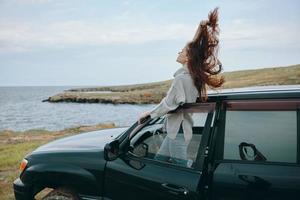 woman with red hair in a sweater near the car nature female relaxing photo