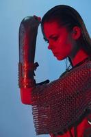 atractivo mujer glamour posando rojo ligero metal armadura en mano estilo de vida inalterado foto