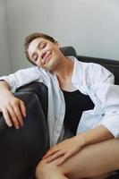 mujer acostado a hogar en el sofá retrato con un corto Corte de pelo en un blanco camisa, sonrisa, depresión en adolescentes, hogar fiesta foto