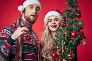 man and woman christmas toys holiday decoration red background photo