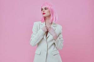 Positive young woman in a suit makeup pink hair posing pink background unaltered photo