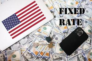 Fixed rate concept. USA flag, dollar money with keys, laptop and phone background. photo