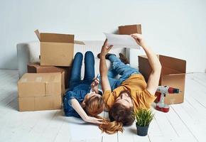 Men and women lie on the floor indoors with boxes of documents of flowers in a pot moving photo