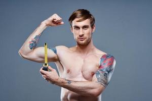 tattooed man muscular bodybuilder Fitness gray background photo