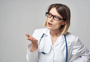 médico en un médico vestido con un estetoscopio alrededor su cuello perplejo Mira gris antecedentes foto