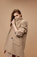 woman closes with beige coat and looks forward side view photo
