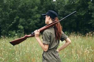 Woman on nature Hunter shotguns walk fresh air green leaves photo