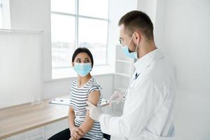 woman in medical mask vaccination in hospital health protection photo