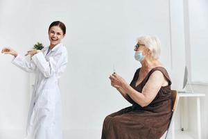 un enfermero dando un inyección a un mayor mujer con un jeringuilla vacuna pasaporte foto