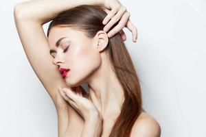 Woman Bare shoulders holding a hand on the head closed eyes red lips bright makeup photo