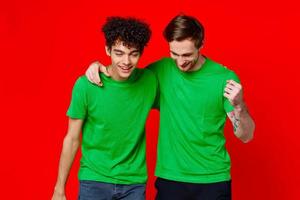 funny friends green t-shirts hugs emotions joy red background photo