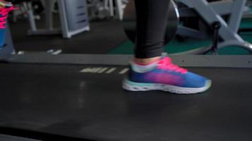 Woman running on treadmill in gym, slow motion video