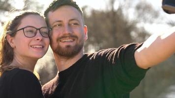 joven Pareja en amor tomando foto de ellos mismos en un película cámara. lento movimiento video