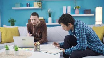 The younger brother gets help from his older brother while studying at home. The younger brother who consults his older brother with a question he cannot solve or understand.  Brothers love. video