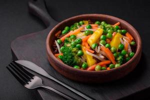 Delicious steamed vegetables broccoli, mushrooms, peas, carrots and onions photo