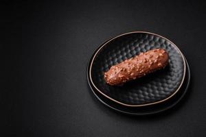 Delicious fresh eclair cake or profiterole with chocolate and nuts photo